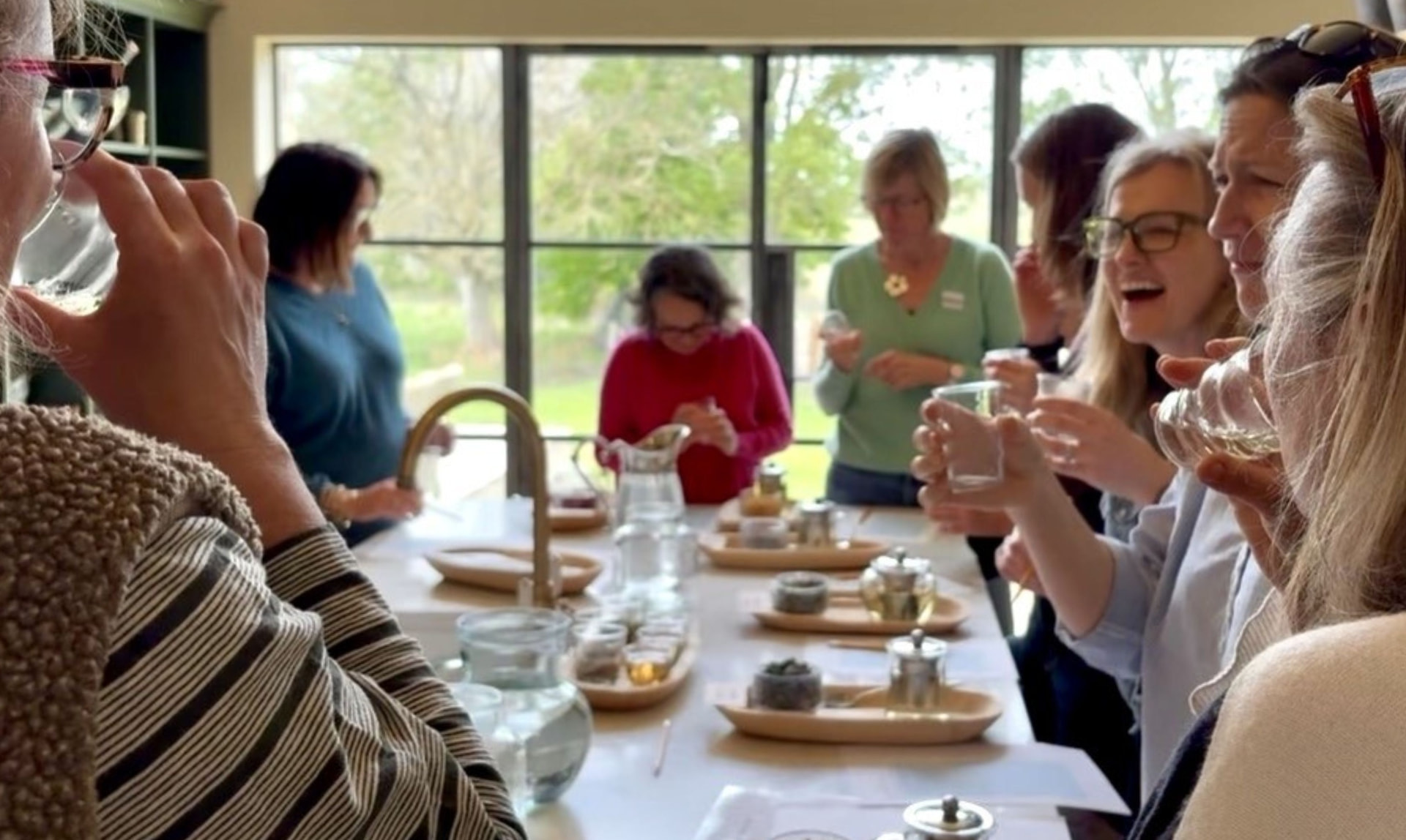 Workshop guests tasting herbal teas and tisanes around a long table